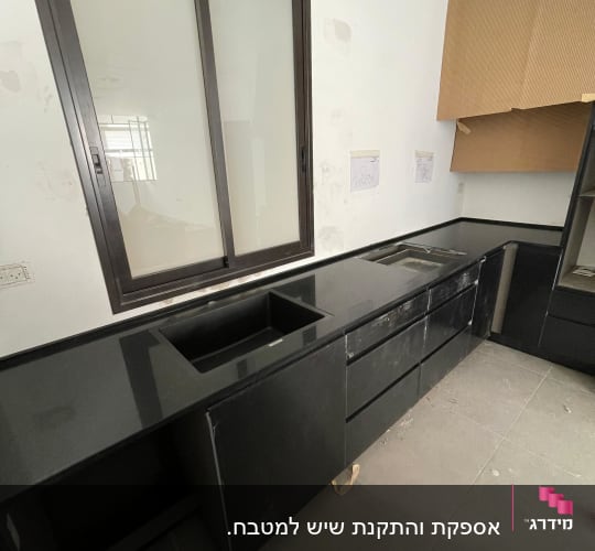 משטח שיש שחור במטבח עם כיור מובנה